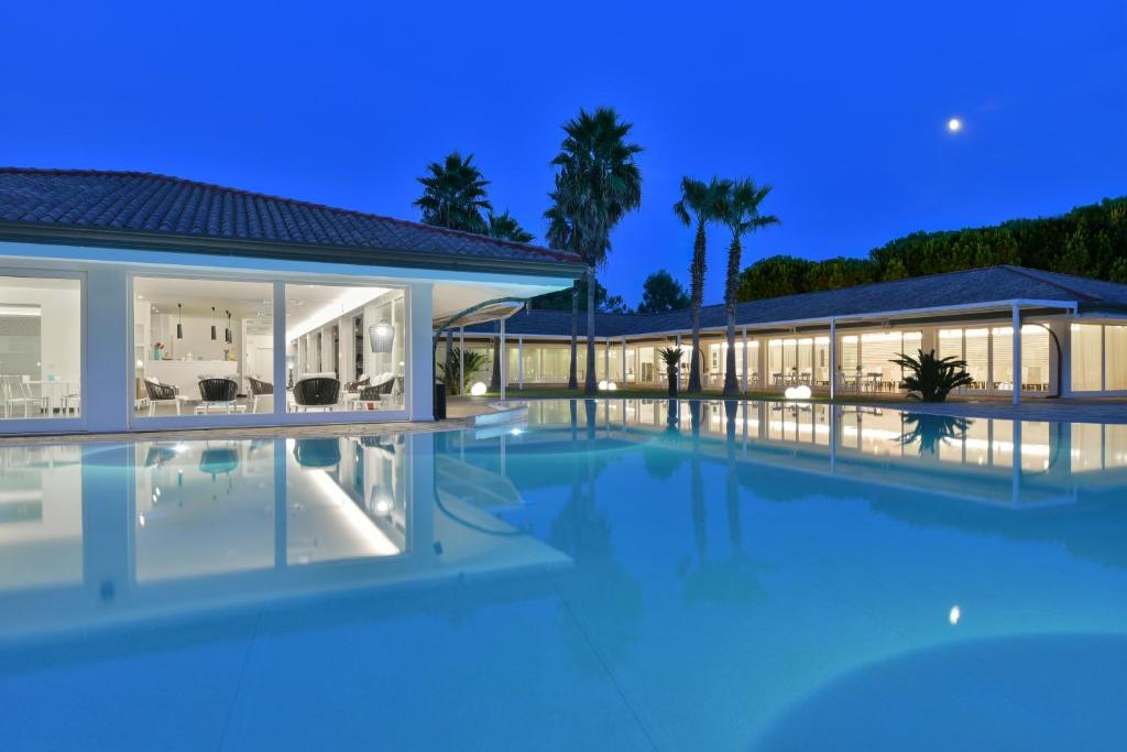 an image of a villa with a swimming pool at night at Paestum Inn Beach Resort in Paestum