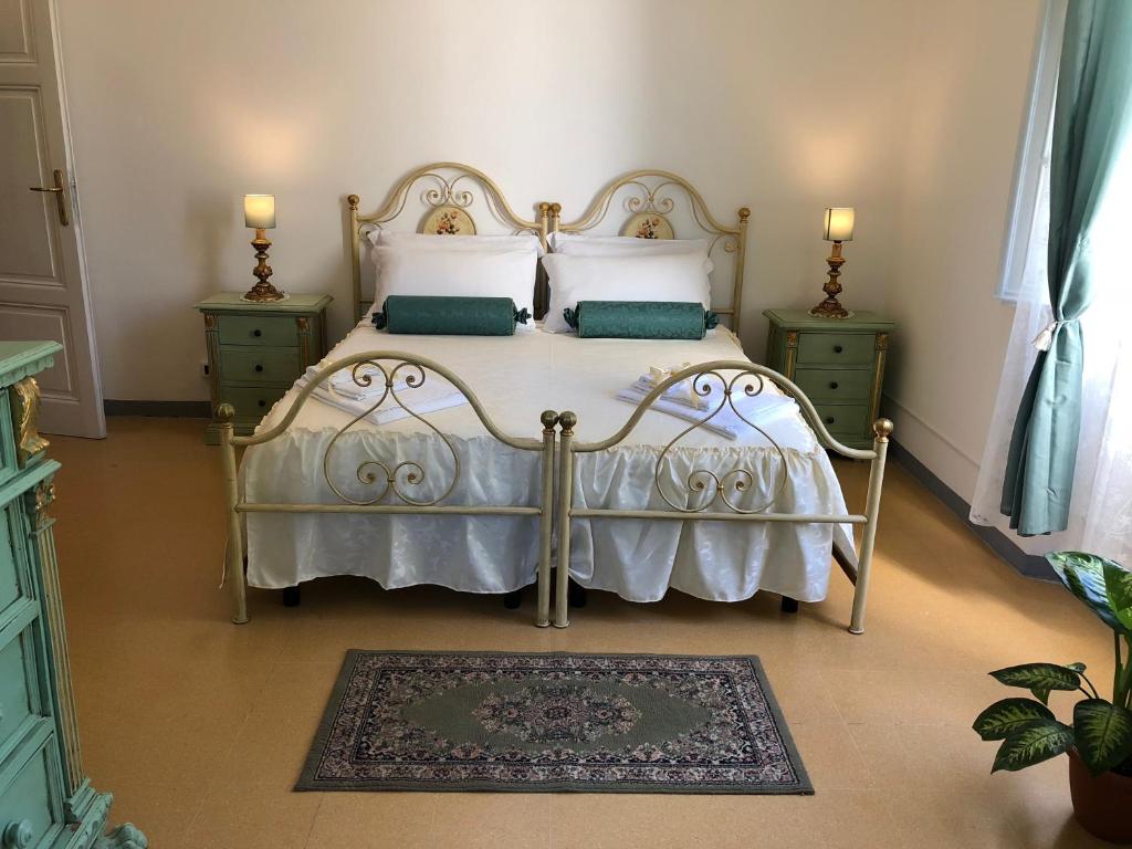- une chambre avec un lit blanc, des oreillers et un tapis dans l'établissement Relais Puccini, à Lucques