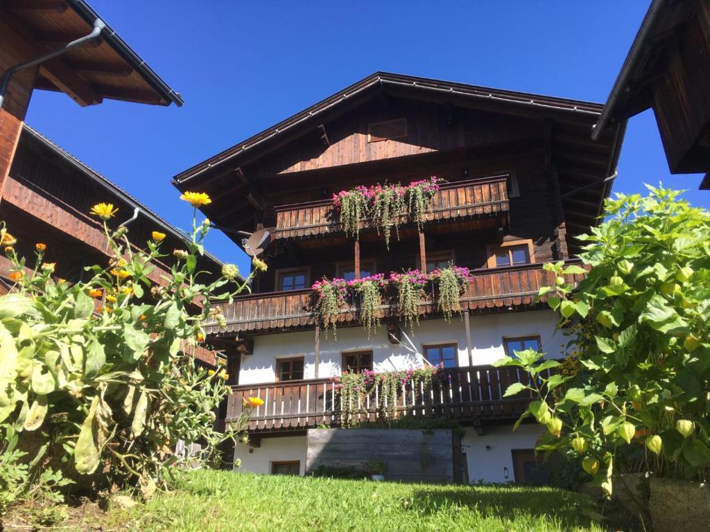 a building with a balcony with flowers on it at Apartments Annewanter in Obertilliach
