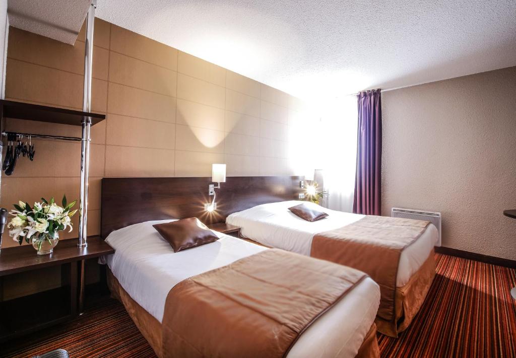 ラングルにあるHôtel Inn Design Resto Novo Langresのベッド2台と窓が備わるホテルルームです。