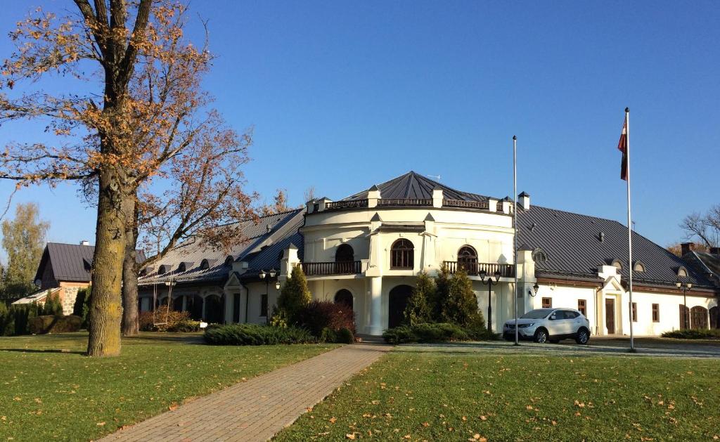 uma casa branca com um carro estacionado em frente dela em Vecgulbenes muiža em Gulbene