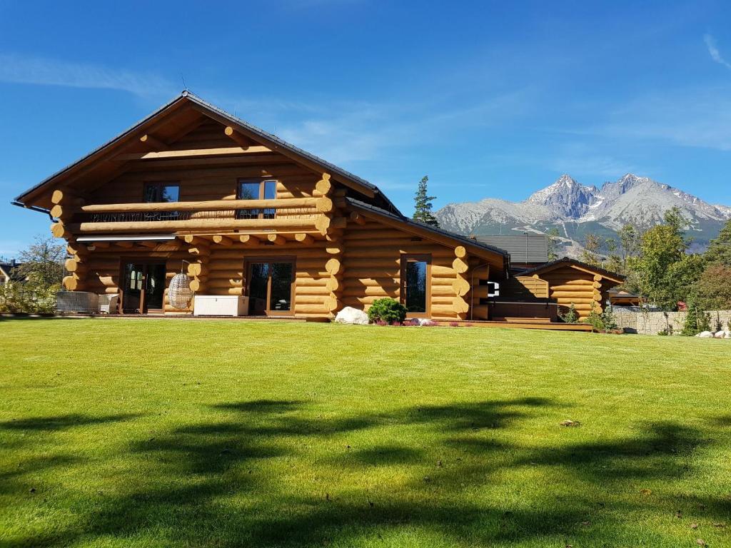 a log cabin with mountains in the background at Chalet - Lomnica in Tatranská Lomnica