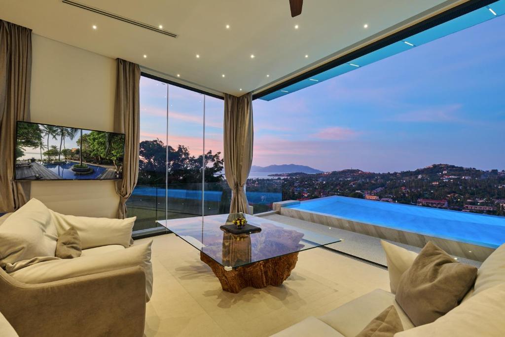 a living room with a large glass window at Magic suites Seaview villas, Koh Samui in Choeng Mon Beach