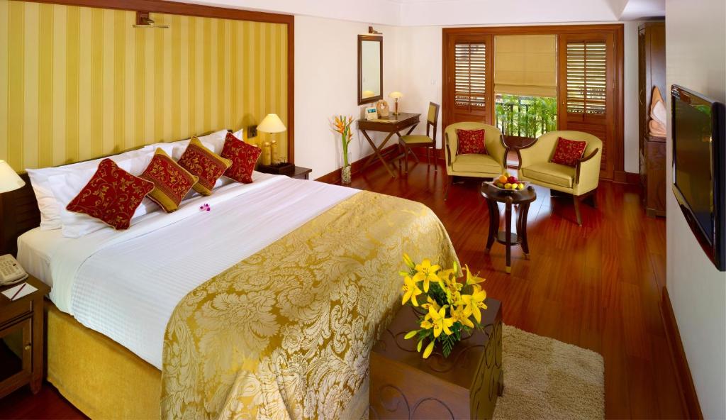 a bedroom with a large bed with red and yellow pillows at The Paul Bangalore in Bangalore