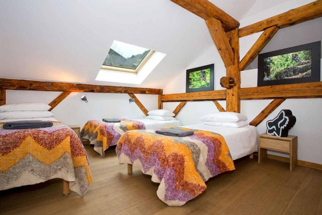 two beds in a room with wooden beams at Hideout Hostel in Morzine