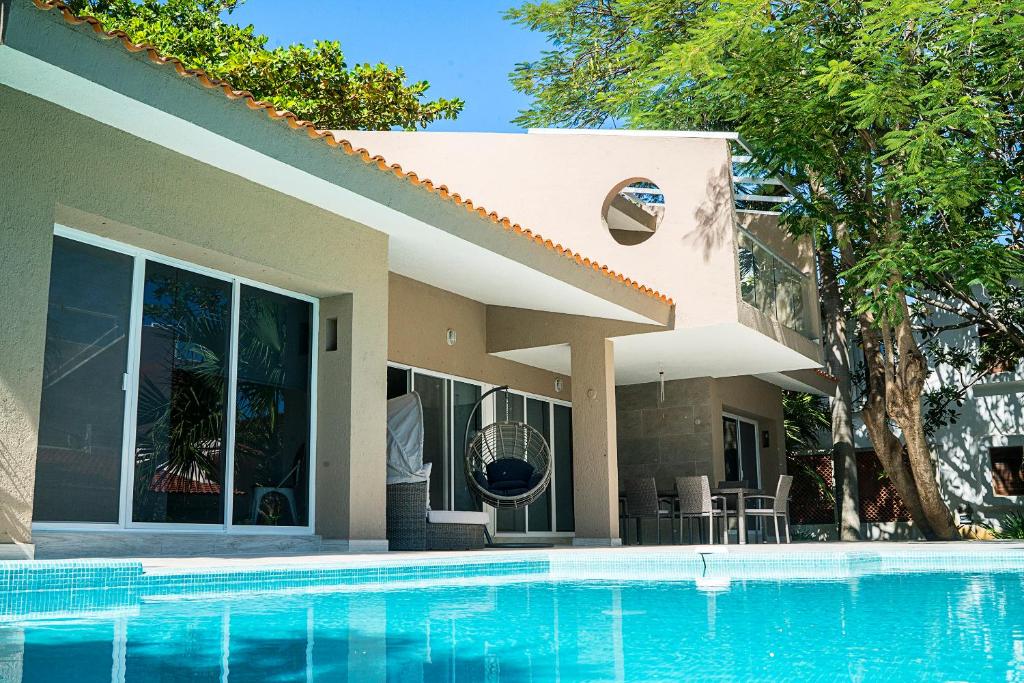 a house with a swimming pool in front of it at 3BR Home, Steps from Spectacular Beach, Private Pool in Playa del Carmen