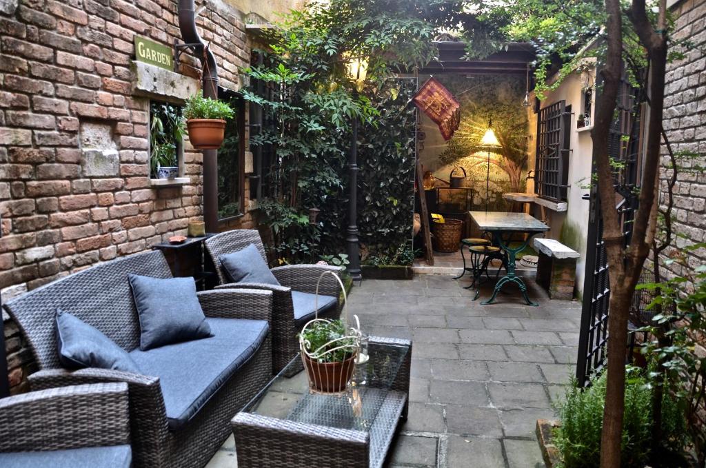 un patio esterno con tavolo e sedie in vimini di "Cà de Casanova" a Venezia
