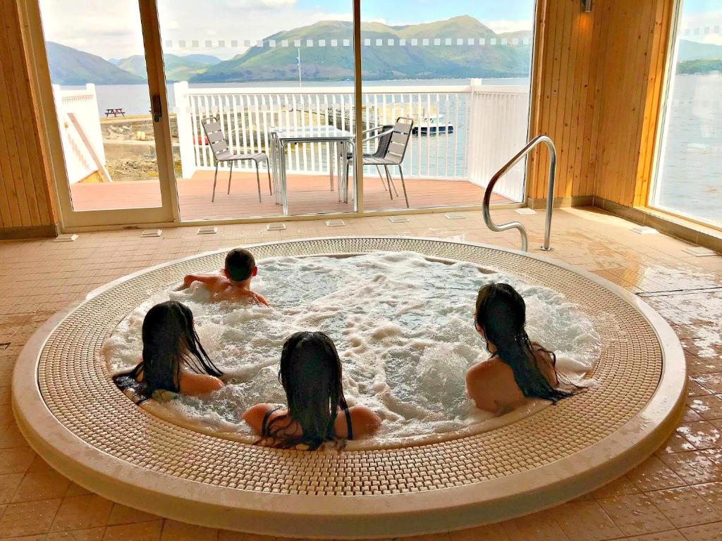 un grupo de tres niños en una bañera de hidromasaje en Holly Tree Hotel, Swimming Pool & Hot Tub en Glencoe