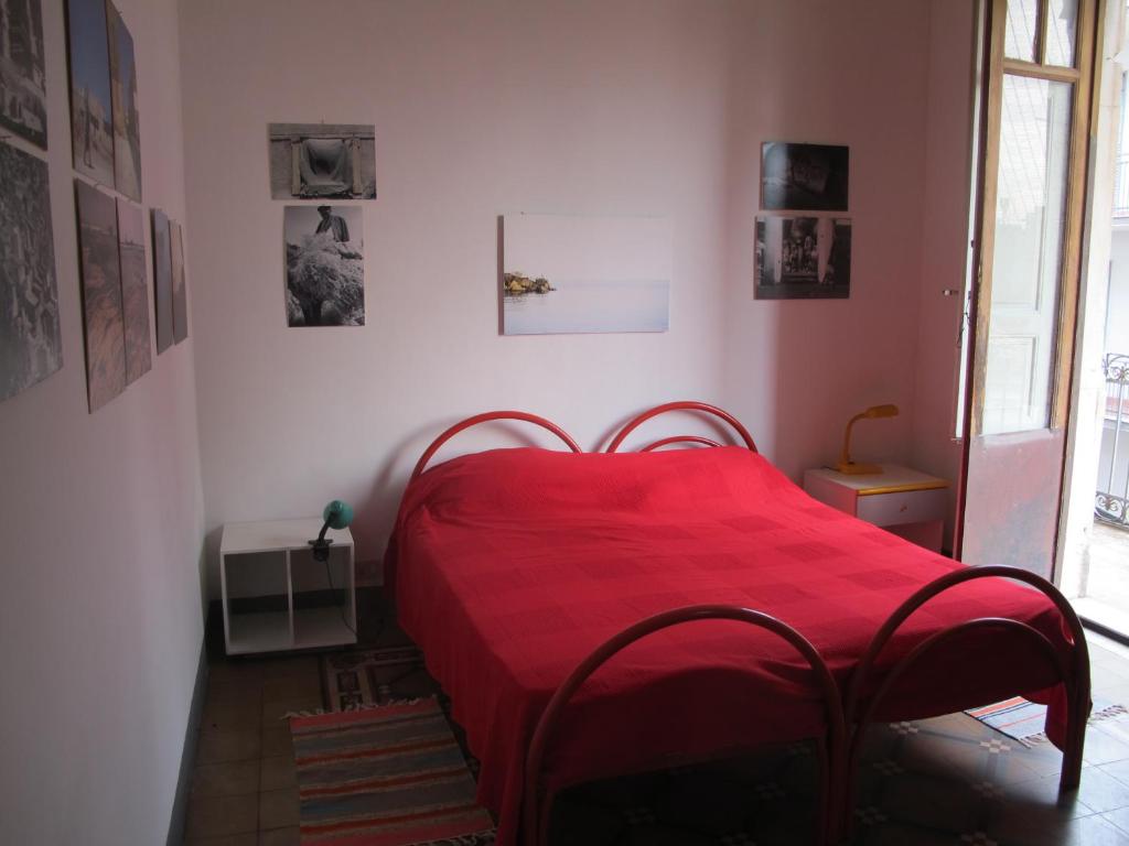 sypialnia z czerwonym łóżkiem i czerwonym kocem w obiekcie Casa Siciliana Etna Mare w Katanii