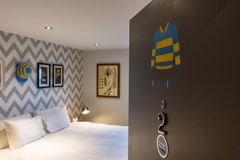 1 dormitorio con 1 cama y un cartel en la pared en Albert Arms en Esher