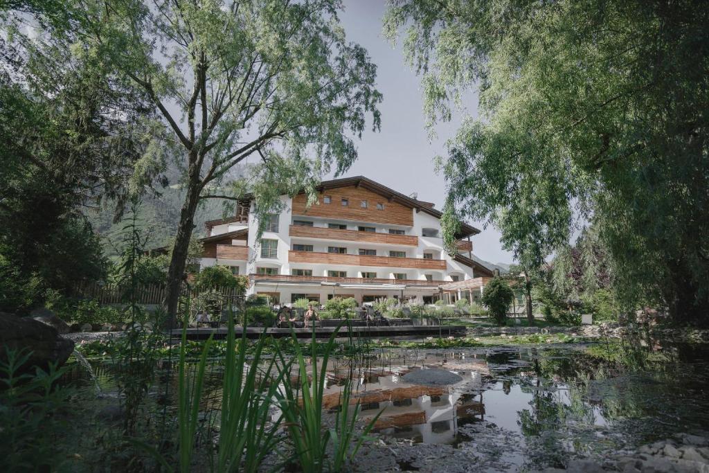 a rendering of a hotel with a pond and trees at Vegan Hotel La Vimea in Naturno