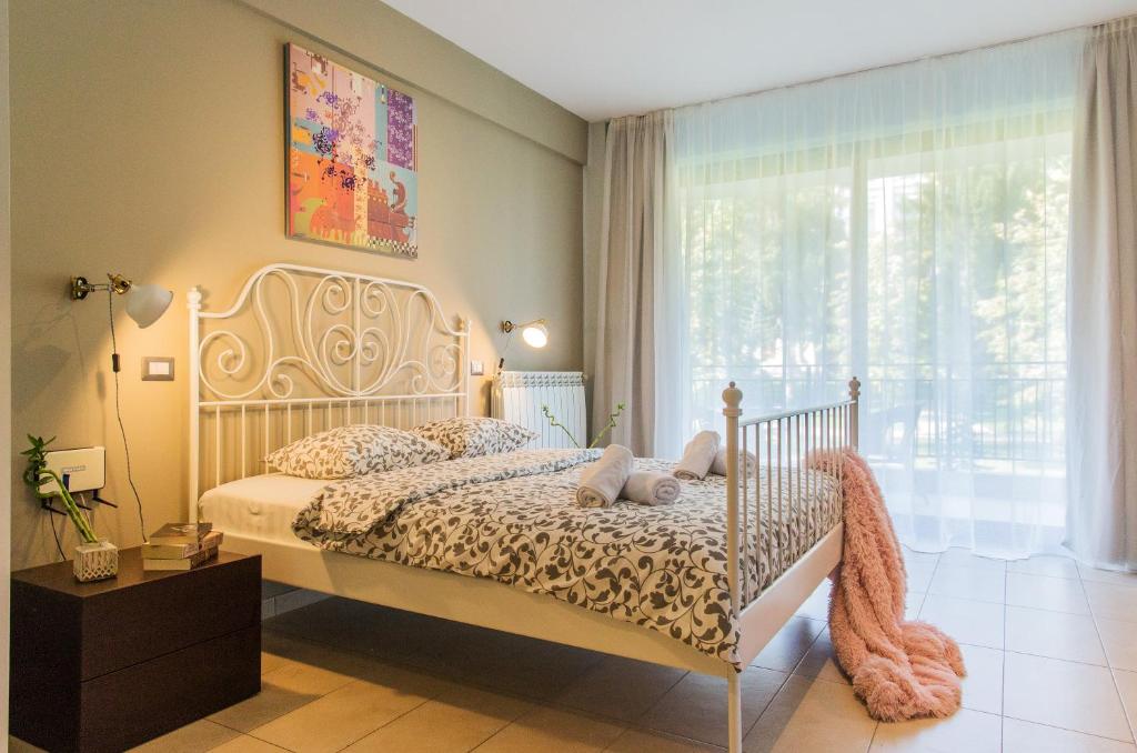 een slaapkamer met een wit bed en een raam bij One Love Metropolitan Gardens Studio in Boekarest