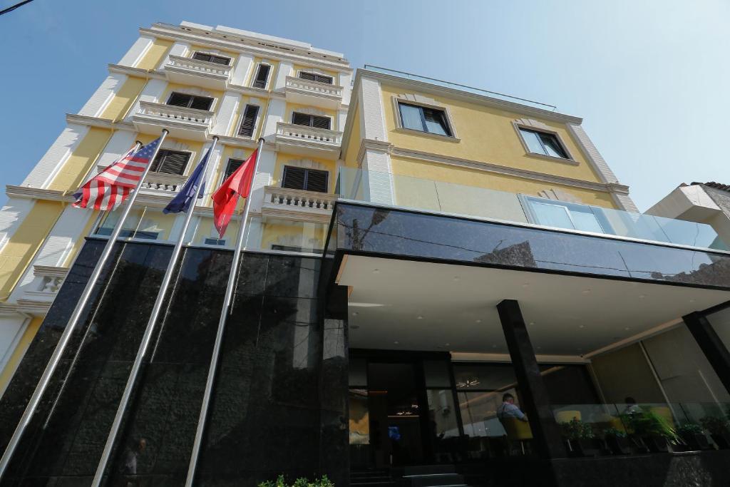 a building with three flags in front of it at Oxford hotel in Tirana