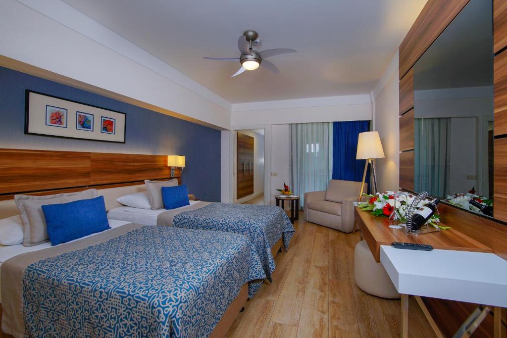 a hotel room with two beds and a table at Limak Atlantis Deluxe Hotel Belek in Belek
