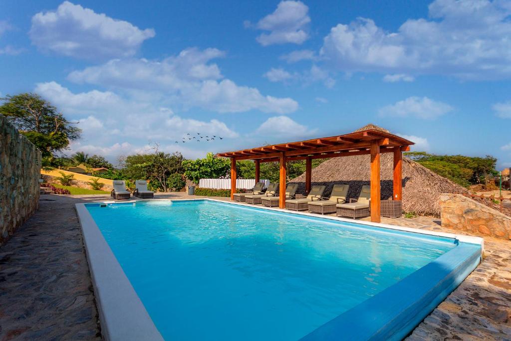 a swimming pool with a gazebo and chairs at Villas & Resort Luz de Luna in Santa Cruz Huatulco