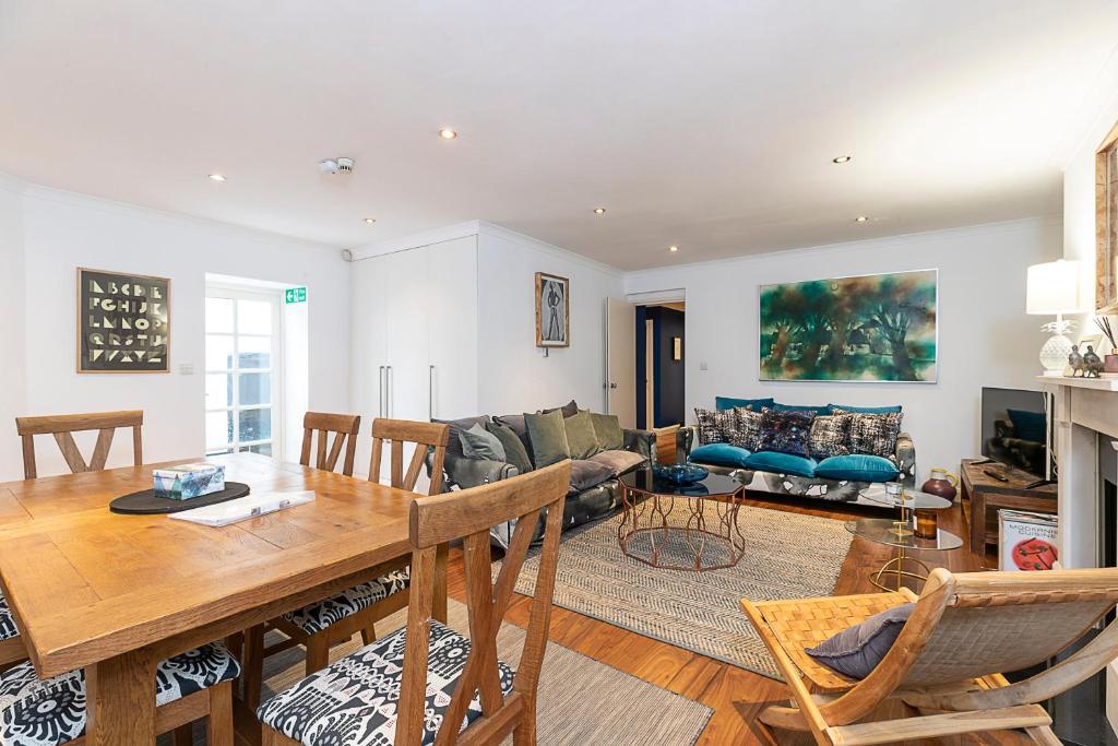 a dining room and living room with a table and chairs at Lovely 2 bedroom flat in Chelsea, sleeps 4 in London