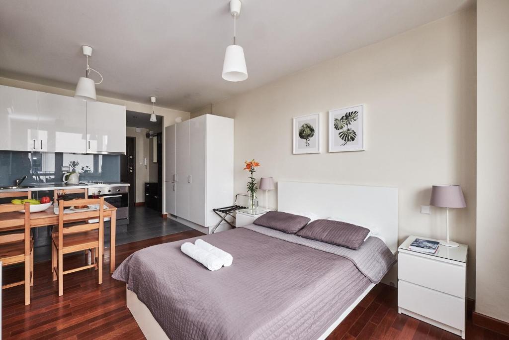 a bedroom with a large bed and a kitchen at Top Ten House Marszałkowska II in Warsaw