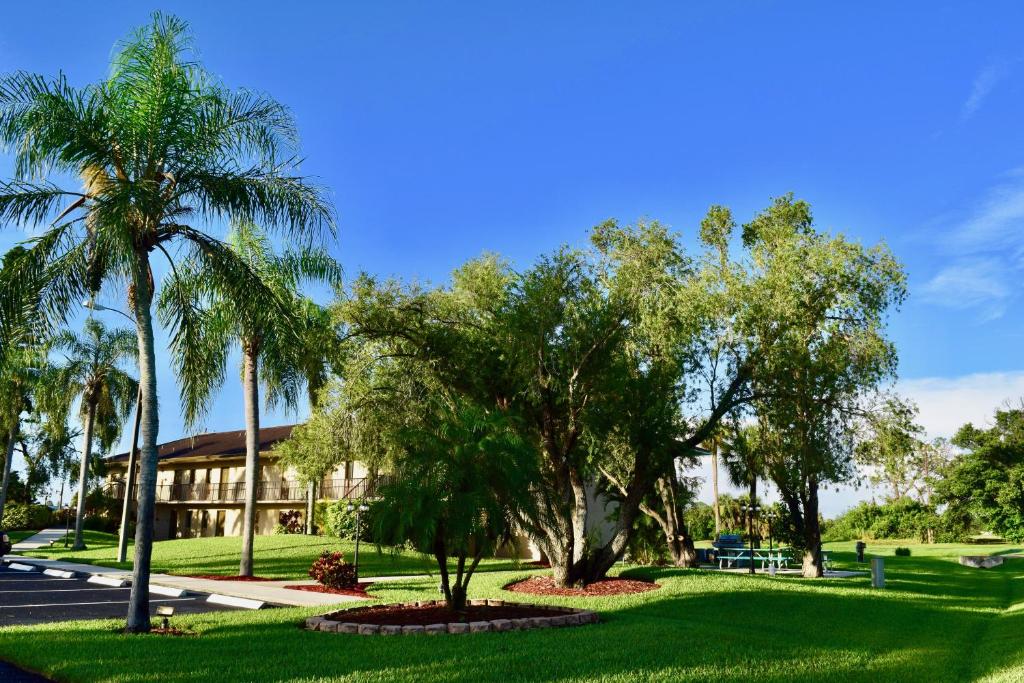 a park with palm trees and a building at Lehigh Resort Club, a VRI resort in Lehigh Acres