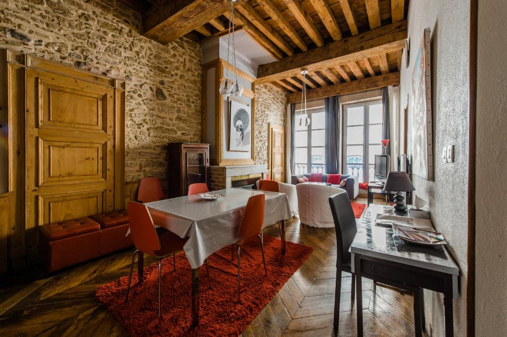 a dining room with a table and chairs and a living room at Constantine Terreaux in Lyon