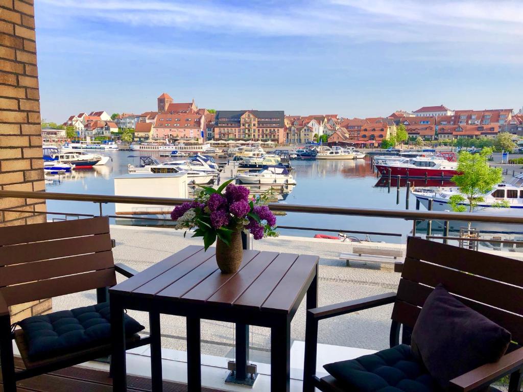 una mesa con flores en un balcón con puerto deportivo en MÜRITZ-BRISE en Waren