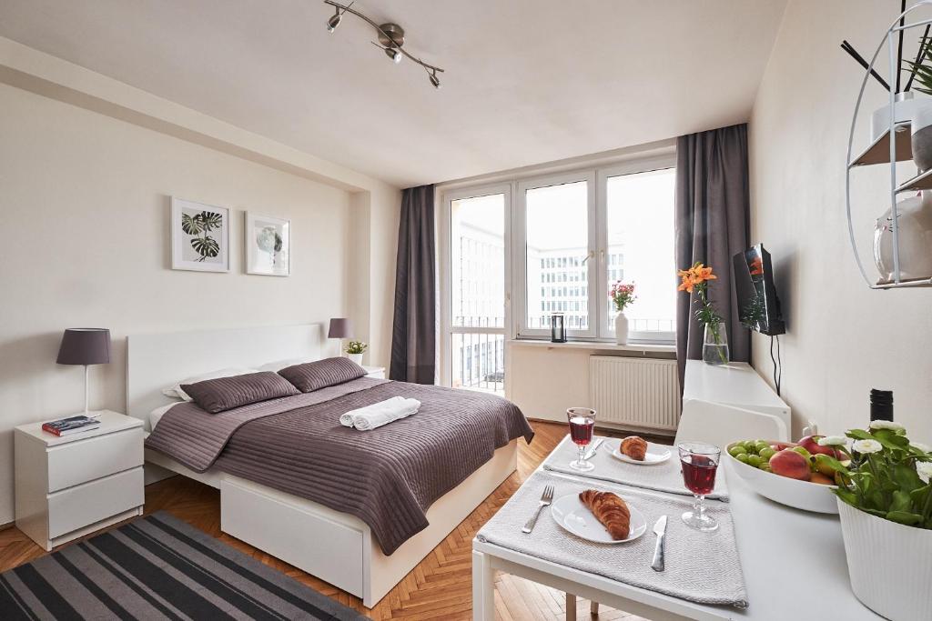 ワルシャワにあるTop Ten House Marszałkowska VIのベッドルーム1室(ベッド1台、テーブル、食べ物付)