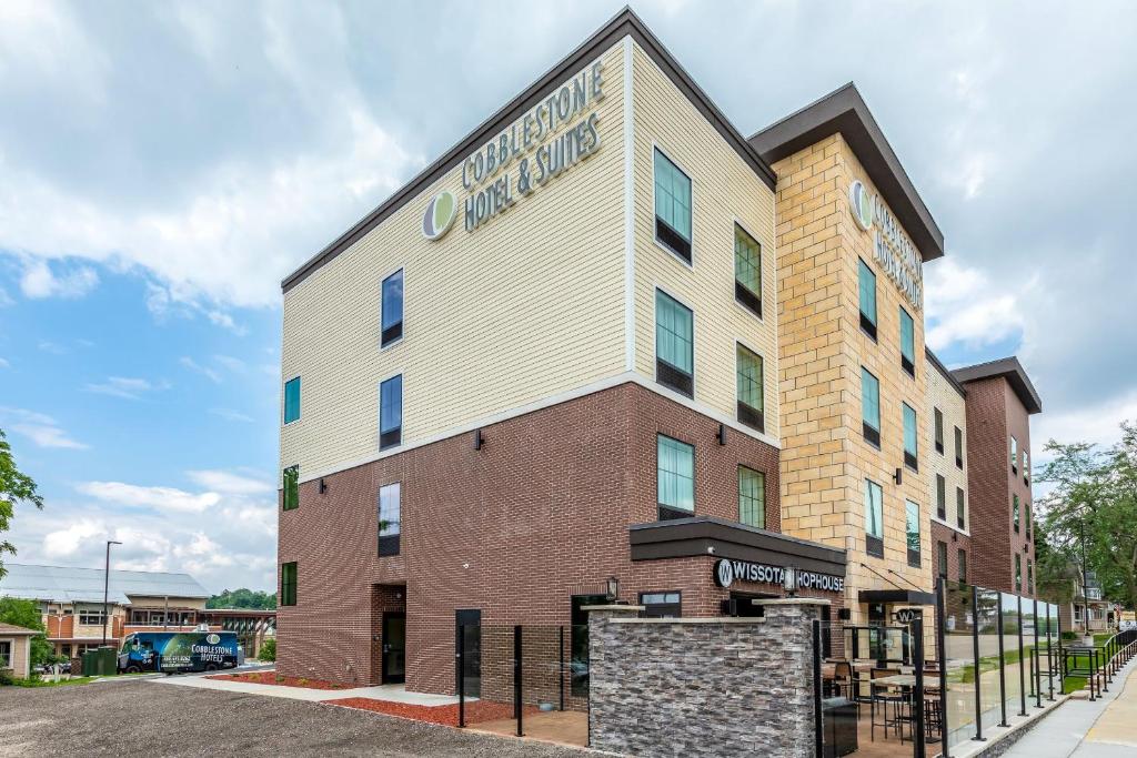 a building with a sign on the side of it at Cobblestone Hotel & Suites Hartford in Hartford