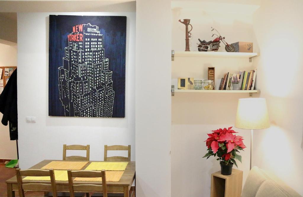 un comedor con una mesa y una pintura en la pared en Alojamiento Mercado de Abastos, en Úbeda
