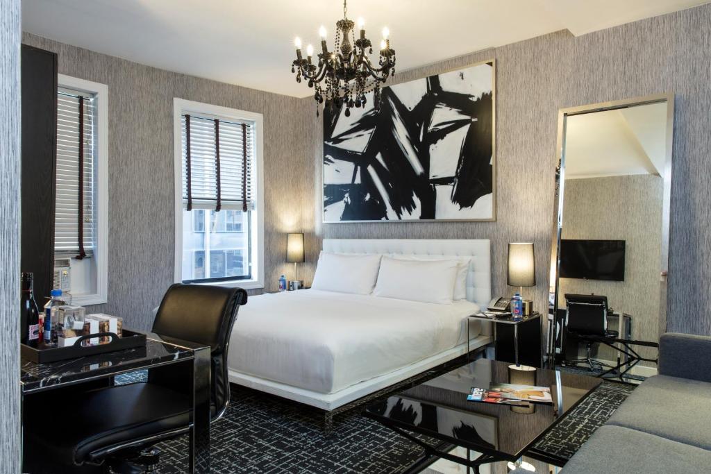 a hotel room with a large bed and a large mirror at Square Hotel at Times Square in New York