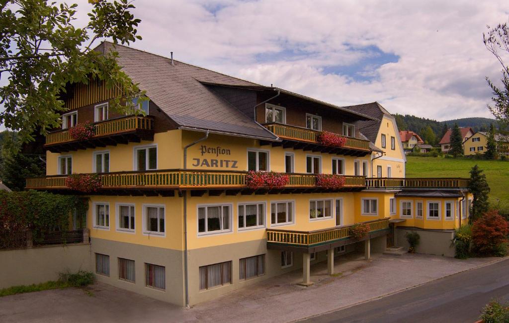 SemriachにあるGasthof-Hotel Jaritzのバルコニー付きの大きな黄色の建物