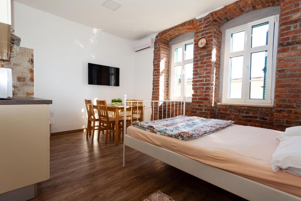 a bedroom with a bed and a brick wall at Lighthouse Rijeka in Rijeka