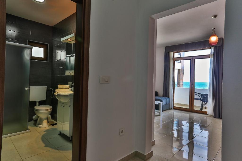 a bathroom with a toilet and a view of the ocean at Apartments Sidro in Dobra Voda