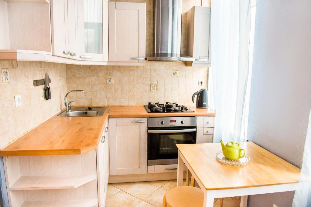ヴィボルグにあるW Apartament Lenina 9の白いキャビネット、シンク、テーブル付きのキッチンが備わります。