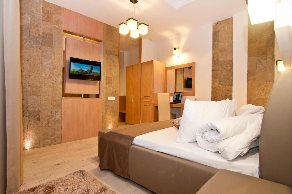 una camera da letto con un letto con cuscini bianchi di Hotel Confort a Cluj-Napoca