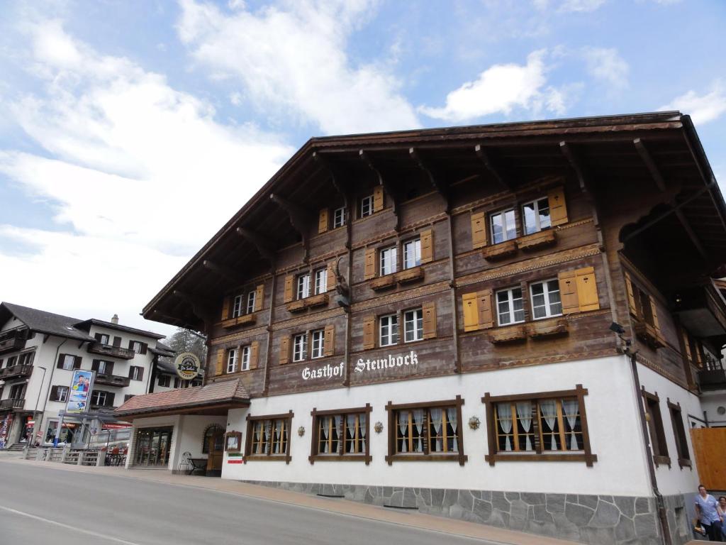 un edificio de madera al lado de una calle en Hotel Steinbock Grindelwald, en Grindelwald