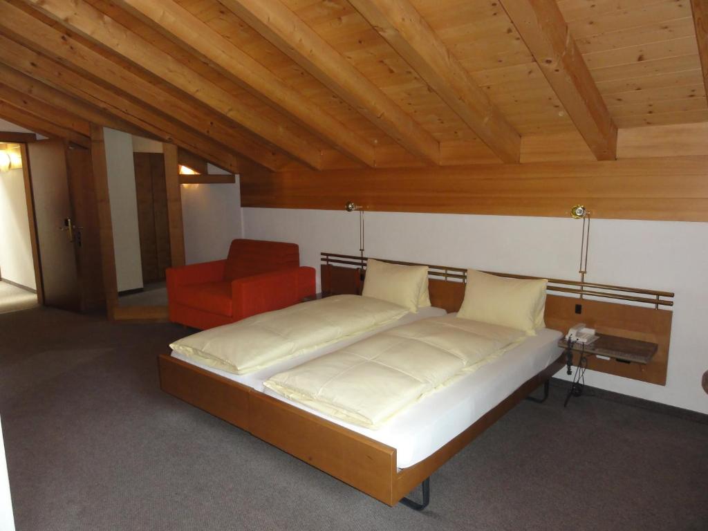 Postel nebo postele na pokoji v ubytování Hotel Steinbock Grindelwald