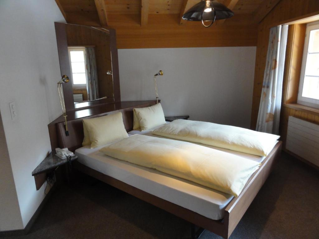 Postel nebo postele na pokoji v ubytování Hotel Steinbock Grindelwald