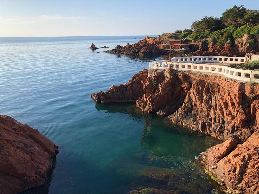 un bâtiment sur une falaise à côté de l'eau dans l'établissement Bright apartment with a garden and a wonderfull sea view, au Trayas