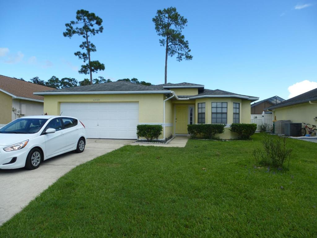 a white car parked in front of a house at The Florida Pad in Kissimmee