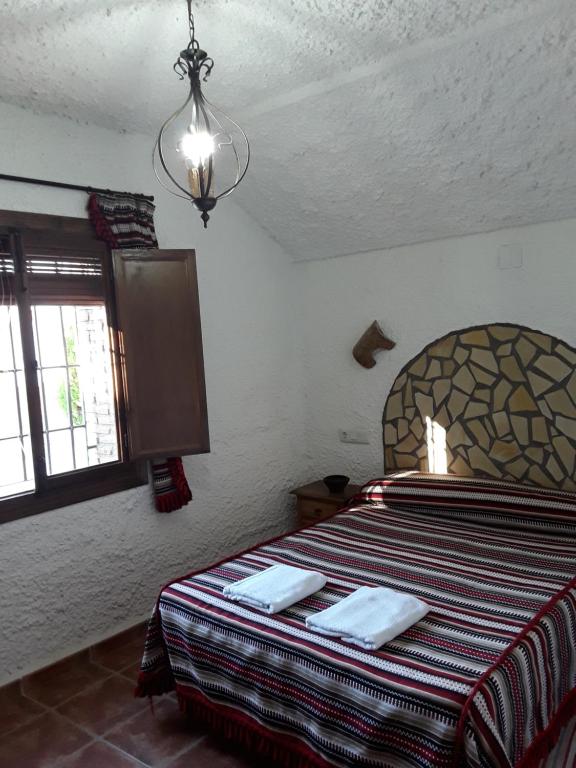 a bedroom with a bed with two towels on it at Cuevas Lourdes in Benamaurel