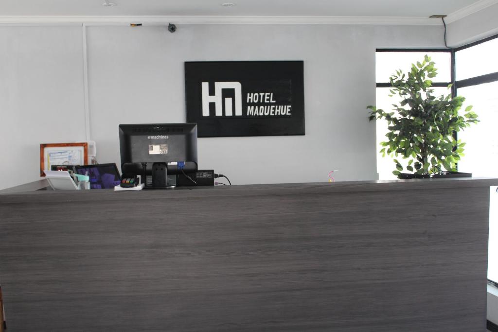 an office counter with a potted plant on top of it at Hotel Maquehue in Concepción