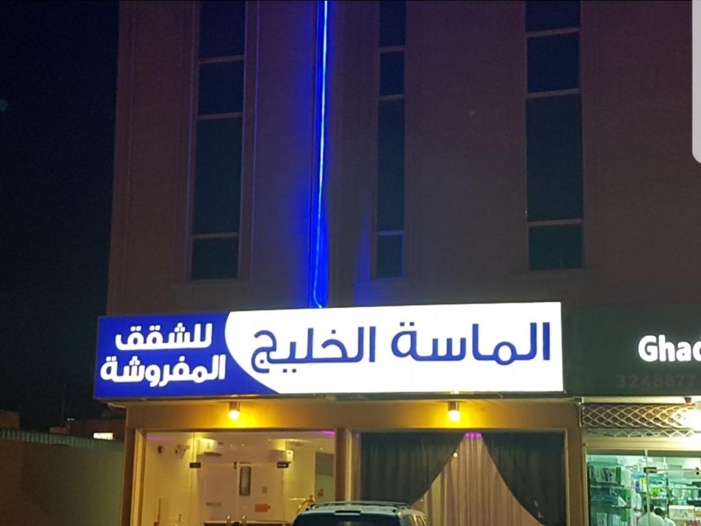 a sign on the side of a building at night at الماسة الخليج للشقق المفروشة in Buraydah