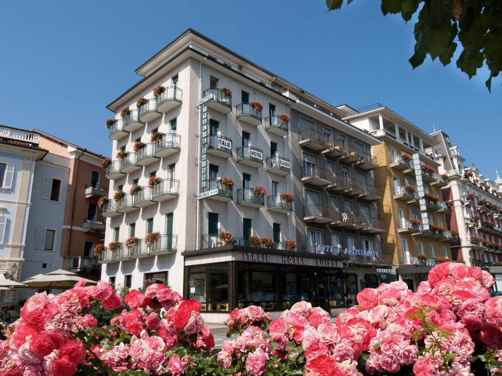 un edificio con flores rosas delante de él en Hotel Italie et Suisse, en Stresa