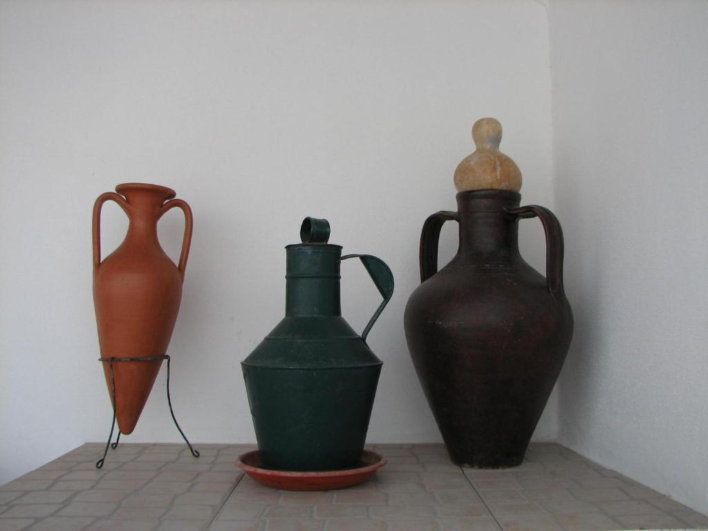 tres jarrones sentados en un piso junto a una pared en Casa da Avó Mina, en Mértola