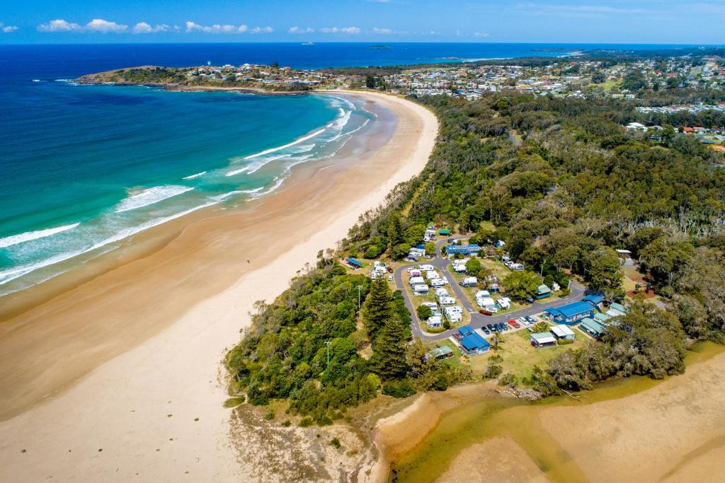 an aerial view of a beach with a group of tents at Woolgoolga Lakeside Holiday Park in Woolgoolga