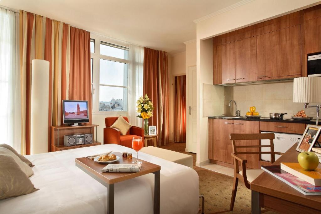 a hotel room with a bed and a living room at Citadines Saint-Germain-des-Prés Paris in Paris