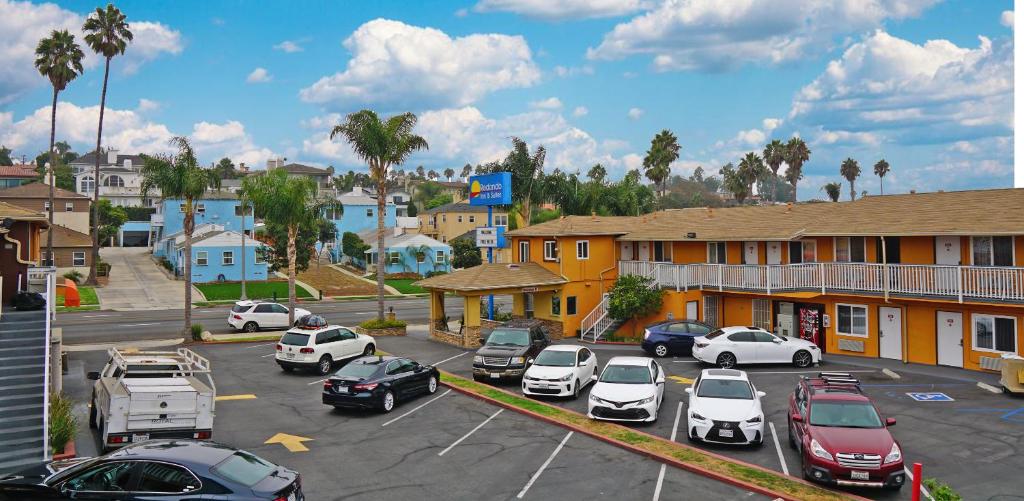 a parking lot with cars parked in front of a building at Redondo Inn and Suites in Redondo Beach