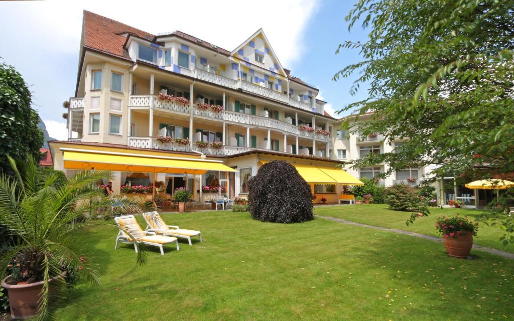 ein großes Hotel mit Stühlen im Hof in der Unterkunft Wittelsbacher Hof Swiss Quality Hotel in Garmisch-Partenkirchen