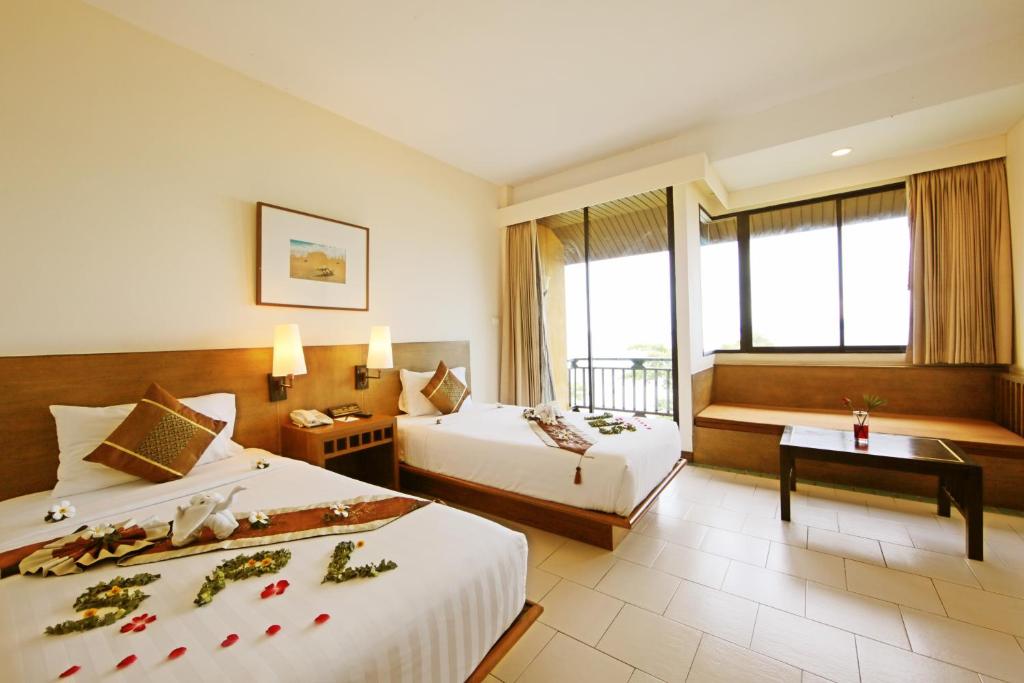a hotel room with two beds and a window at Supalai Scenic Bay Resort And Spa, SHA Extra Plus in Por Bay