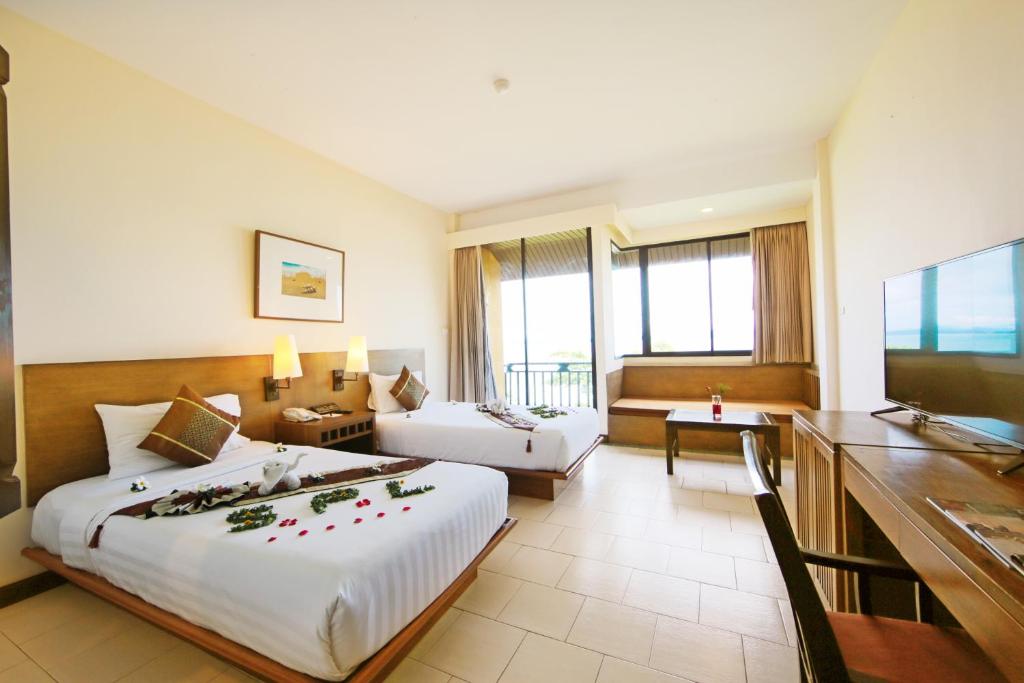 a hotel room with a large bed and a desk at Supalai Scenic Bay Resort And Spa, SHA Extra Plus in Por Bay