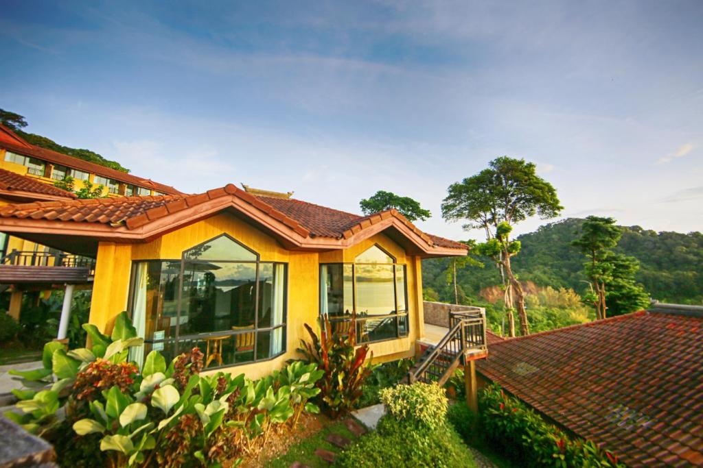 a small yellow house with a roof at Supalai Scenic Bay Resort And Spa, SHA Extra Plus in Por Bay